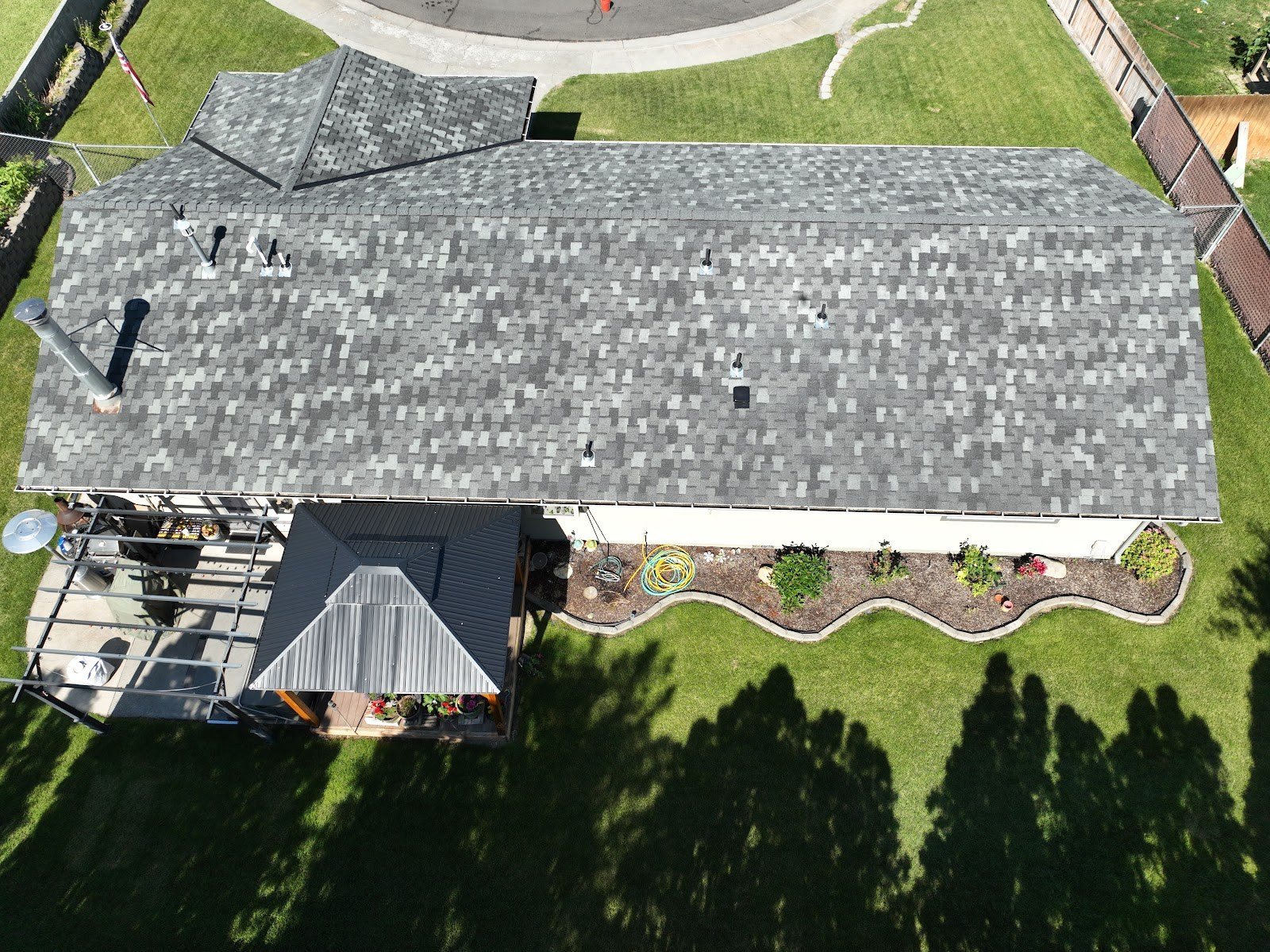 Aerial view of a new shingle roof on a home with fresh landscaping